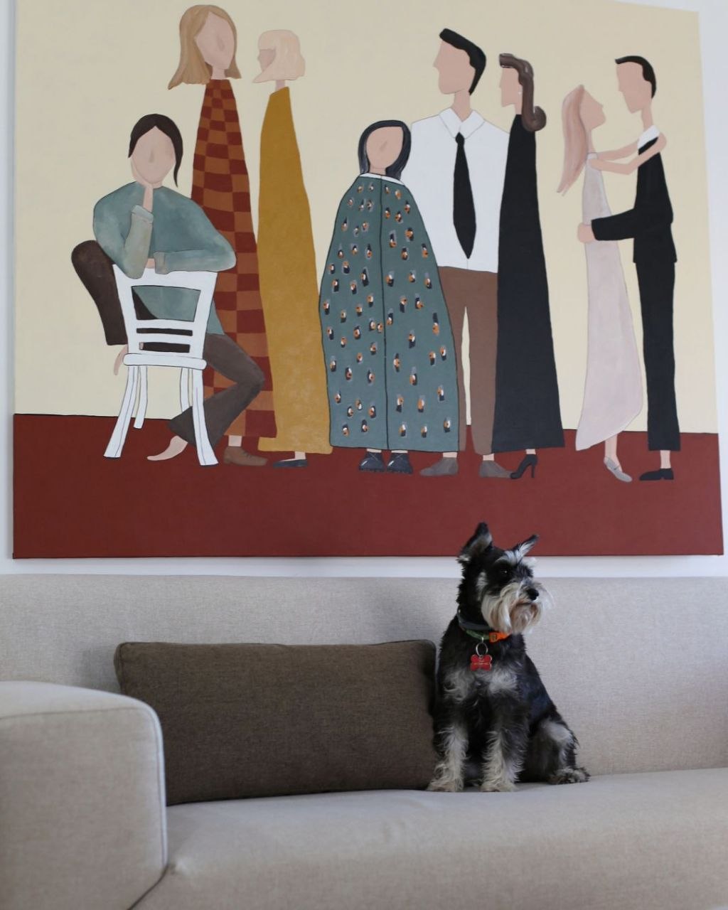 Large Dekart painting above a sofa with a dog in front.